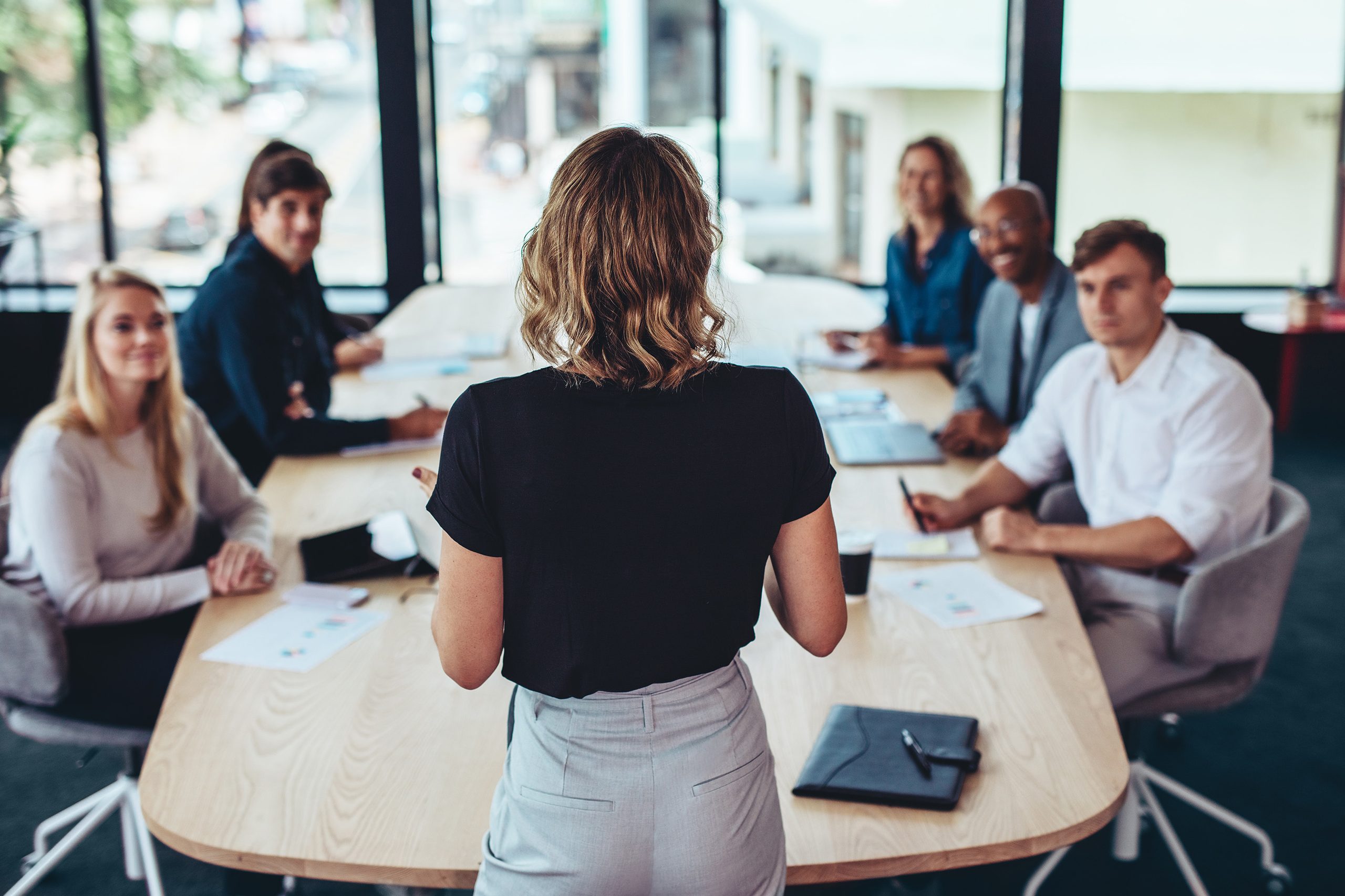 Weibliche Führungsperson vor ihrem Team in einem Meeting.